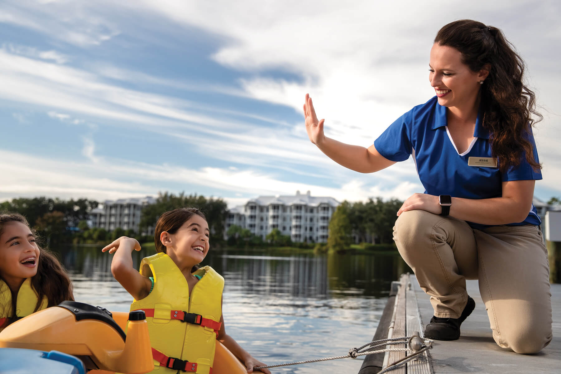 associate high fiving kids in bumper boat